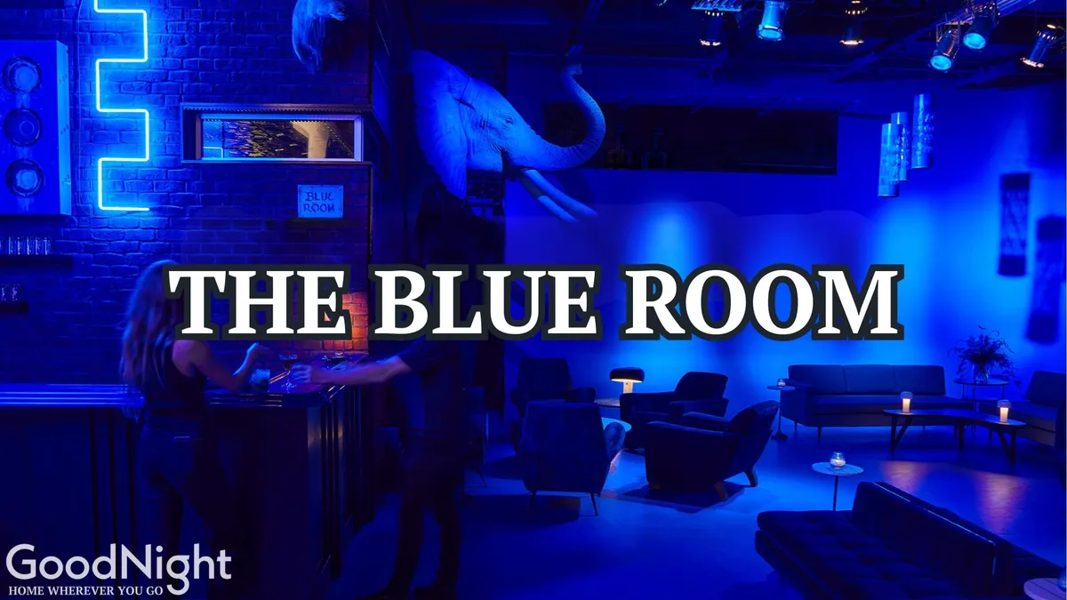 An atmospheric, dimly lit interior scene featuring blue lighting, unique elephant head decor, and plush seating—evoking the mood of a secretive speakeasy or intimate bar.